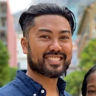 Victor Manansala, standing confidently in a suit and tie, posing for a professional portrait. The image captures his leadership presence and vision.