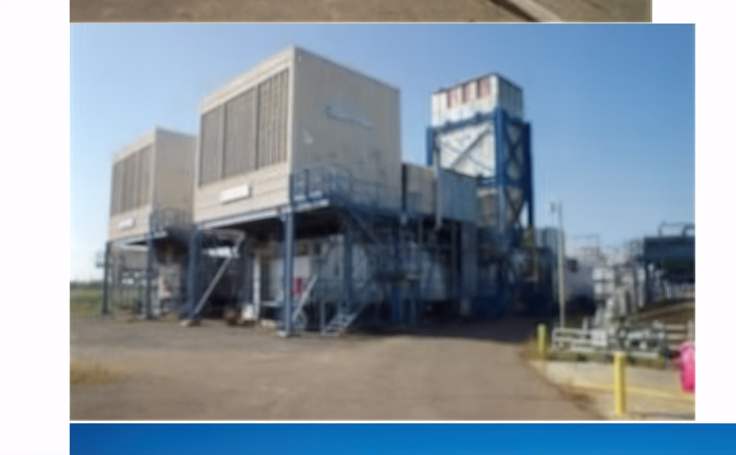 Industrial cooling tower and HVAC system at commercial facility under clear blue sky