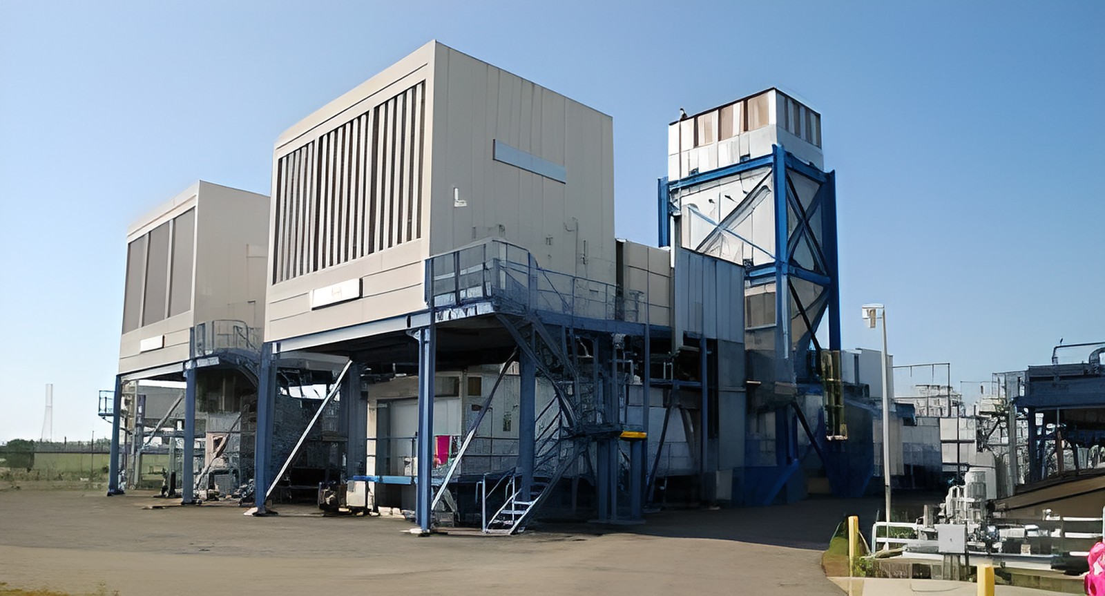 Industrial cooling tower and HVAC system at commercial facility under clear blue sky